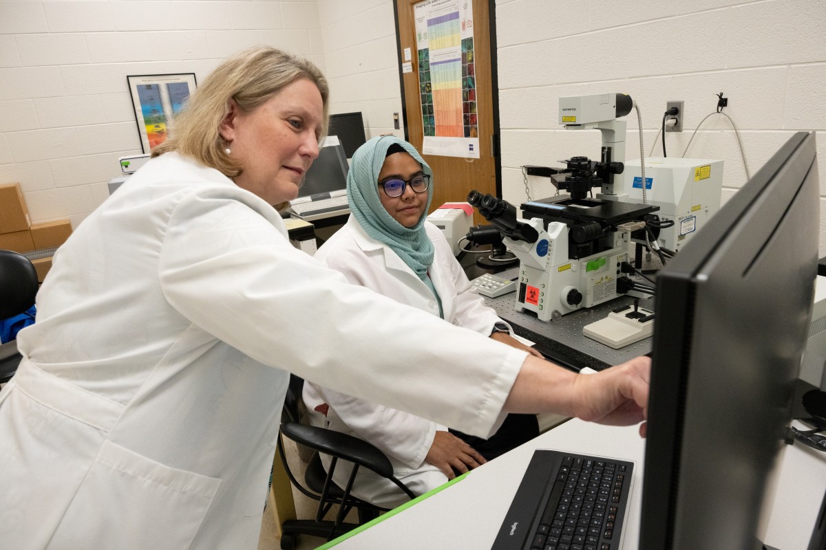 Melinda Frame and student working on the Olympus confocal microscope